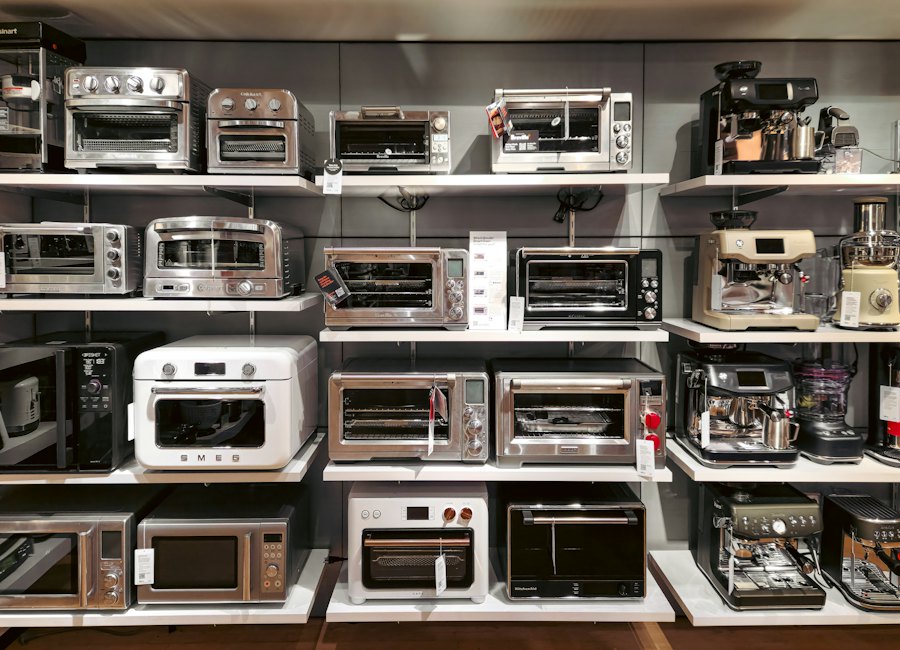 Display of various countertop kitchen appliances including toasters, ovens, and coffee makers arranged on shelves