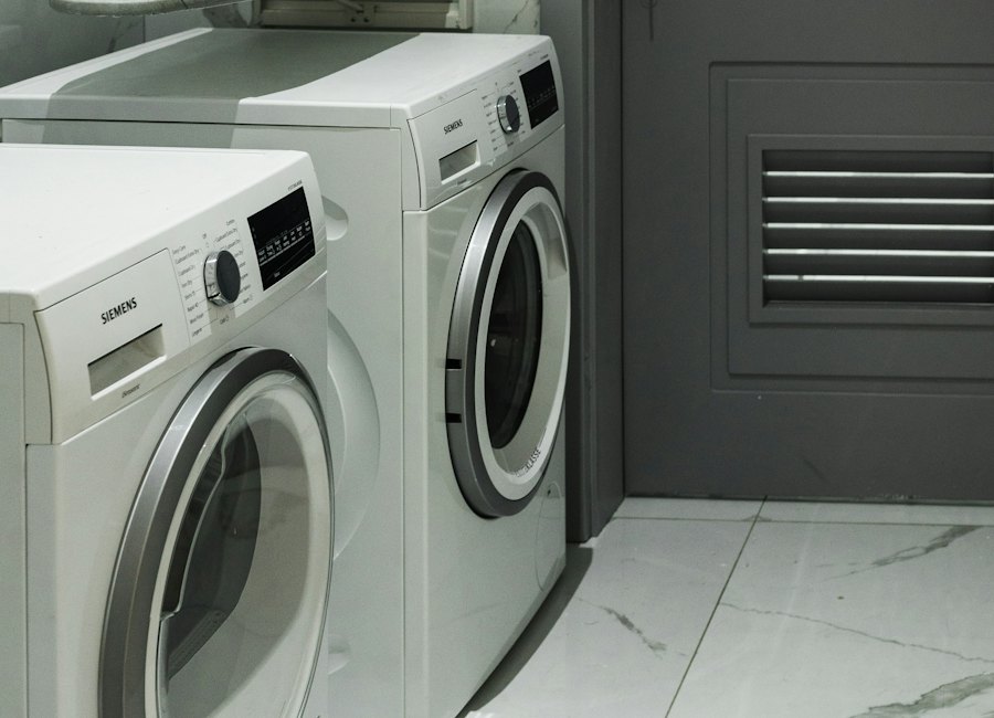 Two white Siemens washing machines in a laundry room with gray walls and marble flooring